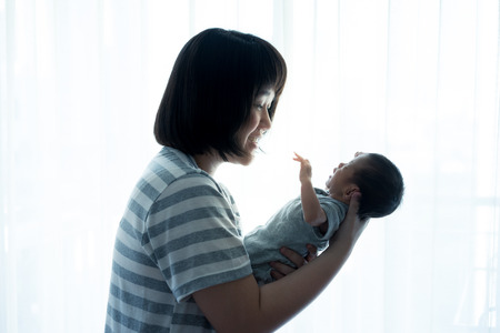 Asian mother holds her  newborn babyの写真素材