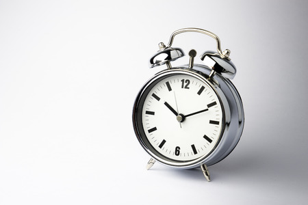 Metal Alarm clock work time on white background 10 am.の写真素材