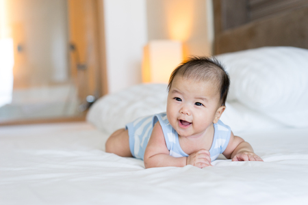 Portrait of a newborn Asian baby on the bedの写真素材