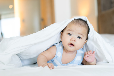 Portrait of a newborn Asian baby on the bedの写真素材
