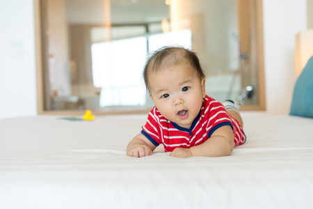 Portrait of a newborn Asian baby on the bedの写真素材
