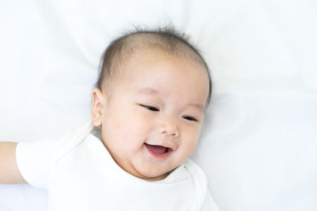 Portrait of a newborn Asian baby on the bedの写真素材