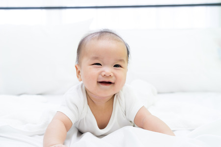 Portrait of a newborn Asian baby on the bedの写真素材