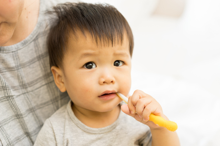 Asian baby uses toothbrushの写真素材
