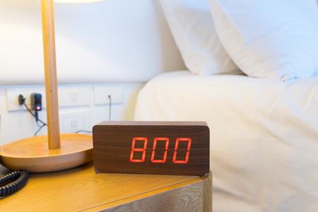 Alarm clock work time on the bed 8 am.の写真素材