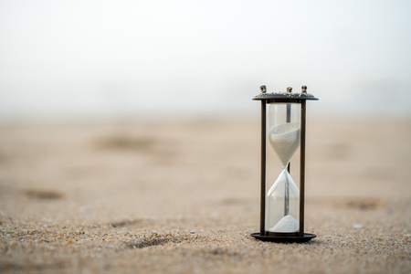 Sand clock on the beach, business time management conceptの写真素材