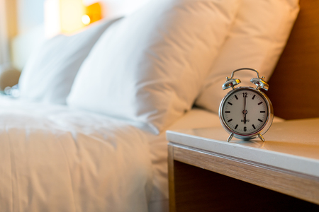 Metal Alarm clock on white bedroomの写真素材