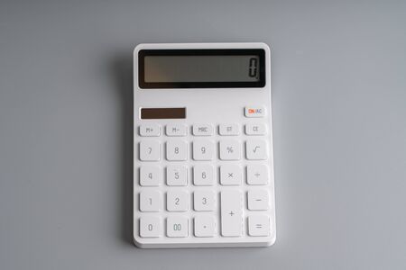 White calculator on grey background for education & business conceptの写真素材