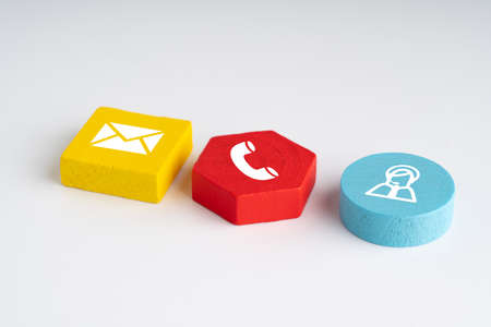 Contact us icon on colorful puzzle with handの写真素材