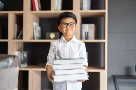 Asian boy holds books at libraryの写真素材