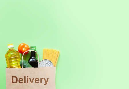 Delivery box with various products on green background. Food donations or delivery concept.の写真素材