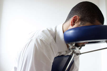 businessman receiving shiatsu on a quick massage chairの写真素材