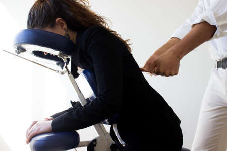 business woman receiving shiatsu on a quick massage chairの写真素材