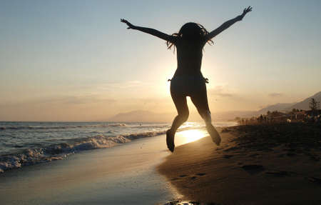 Girl jumping on the beachの写真素材