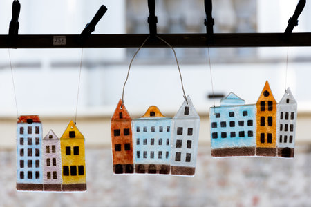 Colorful tempered glass houses hanging on a rope in front of the windowの写真素材