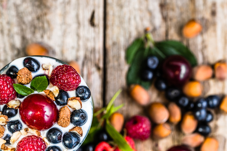 Yogurt ice cream with berry fruits and hazelnuts in a glass cup, frozen dessert, summer healthy eating concept, view from aboveの写真素材