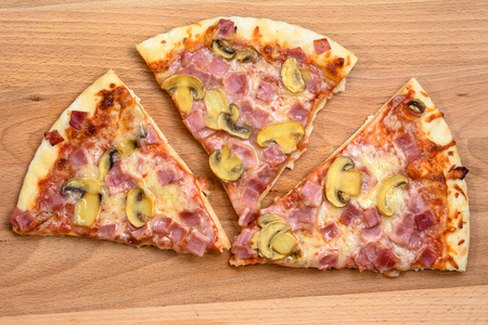 Pieces of pizza on wooden board.の写真素材
