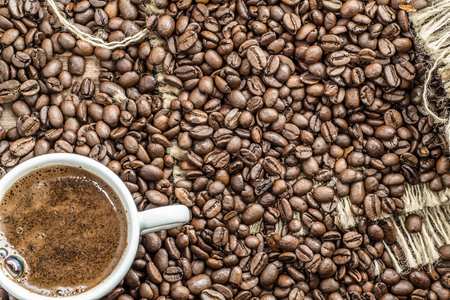 Cup of coffee and coffee beans on wooden tableの写真素材