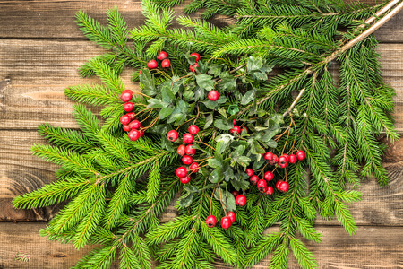 Christmas tree twigs of spruce and Christmas ornaments arranged on rustic wood backgroundの写真素材