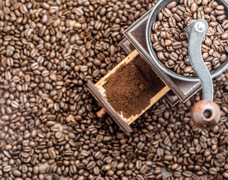 Manual coffee grinder with roasted coffee beans, overheadの写真素材