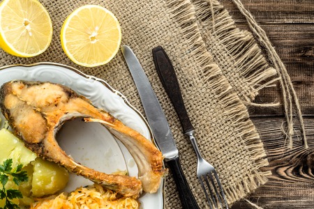 Fried fish, boiled potatoes and sauerkraut, dinner, cooking concept, top viewの写真素材