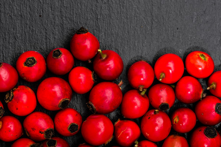 Macro of rose hip, natural background, top view on black boardの写真素材