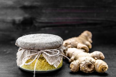 Grated ginger in jar on black background, spices in cuisine for cooking and treatmentの写真素材