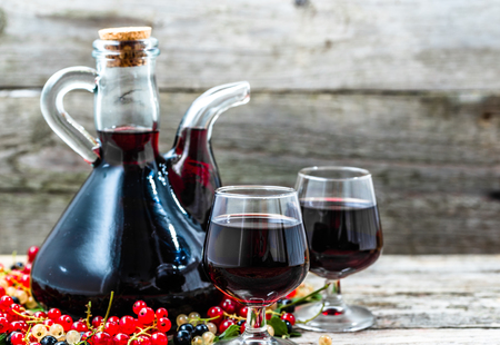 Old wine carafe on wooden table. Sweet alcohol made from fruits many variety berries currantの写真素材