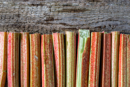 Fresh rhubarb stalks on wooden table, top view, copy spaceの写真素材