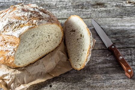 Fresh baked bread loaf on rustic wooden table, baking concept