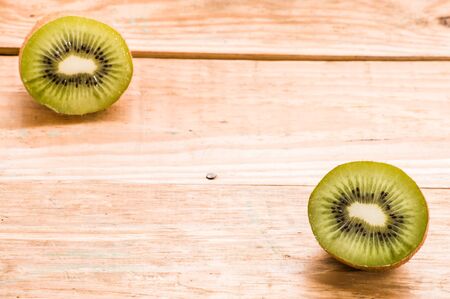 Two halves of kiwi on a wooden backgroundの写真素材