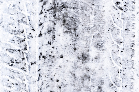 Snow on road with tire tracks, winter textureの写真素材