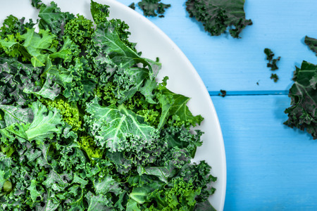 Green kale, healthy vegetable chips from sliced leaves, vegetarian food conceptの写真素材