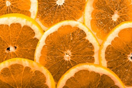 Background with orange fruits, slices, texture, macro