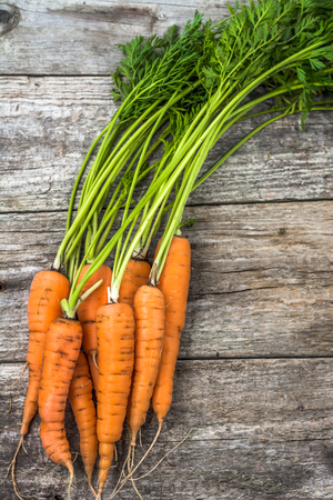 Fresh carrots bunch with leaves. Vegetables on farmer marketの写真素材