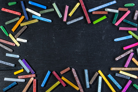 Colorful frame with chalk on chalkboard black background with space for text, back to school concept, flat layの写真素材