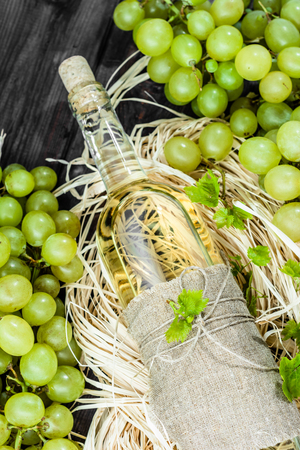 White wine bottle from green grape. Homemade wine in aged wooden pantry.の写真素材