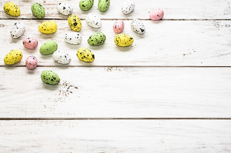 Easter background with colorful easter eggs on white wooden boards