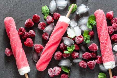 Raspberry popsicles on ice with cream fillingの写真素材