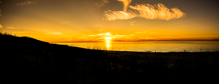 Silhouette of sunset beach, panorama with sun on the sky going to the sea, summer landscapeの写真素材