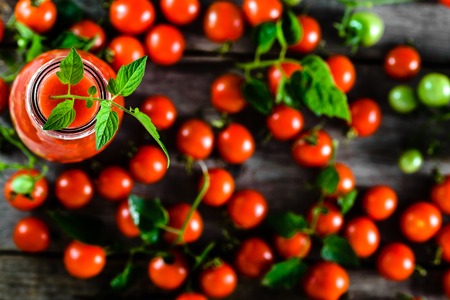 Bottle of tomato juice and fresh tomatoes, healthy food, organic diet concept, overheadの写真素材