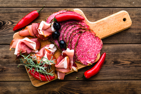 Cold meat platter with salami, slices ham prosciutto, italian antipasti on wooden boardの写真素材