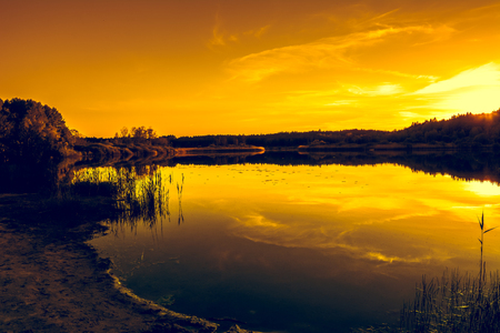 Summer scenery of sunset sky over peaceful lake with calm water surface, nature landscapeの写真素材