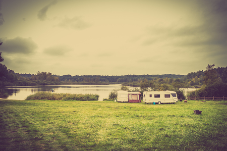 Caravan camping on the lake in the summer vacation. Camp with camper trailers.の写真素材