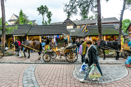 ZAKOPANE, POLAND - AUGUST 17, 2016: Main promenade in Zakopane, tourist on the street with shops, people enjoy local folclore in Poland, tourism in the summerのeditorial素材