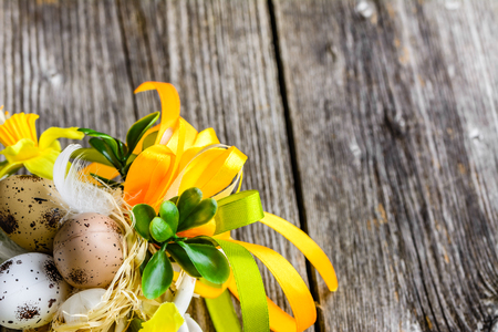Easter background with easter eggs and spring flowers on wooden tableの写真素材