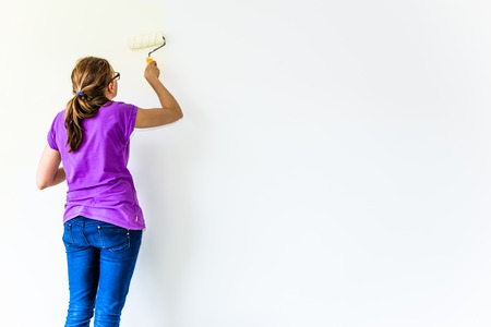 Painting wall using paint brush, working indoors, home renovation conceptの写真素材