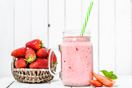 Fruit smoothie with strawberries, milkshake with fresh strawberry blended in jar on white backgroundの写真素材
