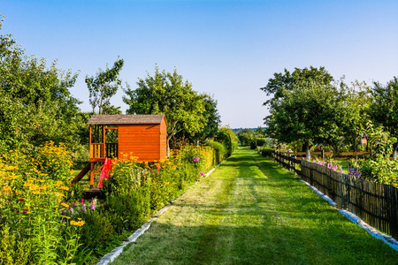 Garden path and summer children house in the garden, cottage playhouse for kidsの写真素材