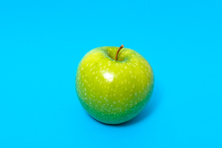 Fresh green apple isolated on blue backgroundの写真素材
